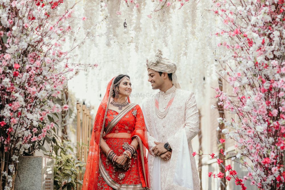 Photo of contrasting bride and groom portrait with cherry blossom mandap