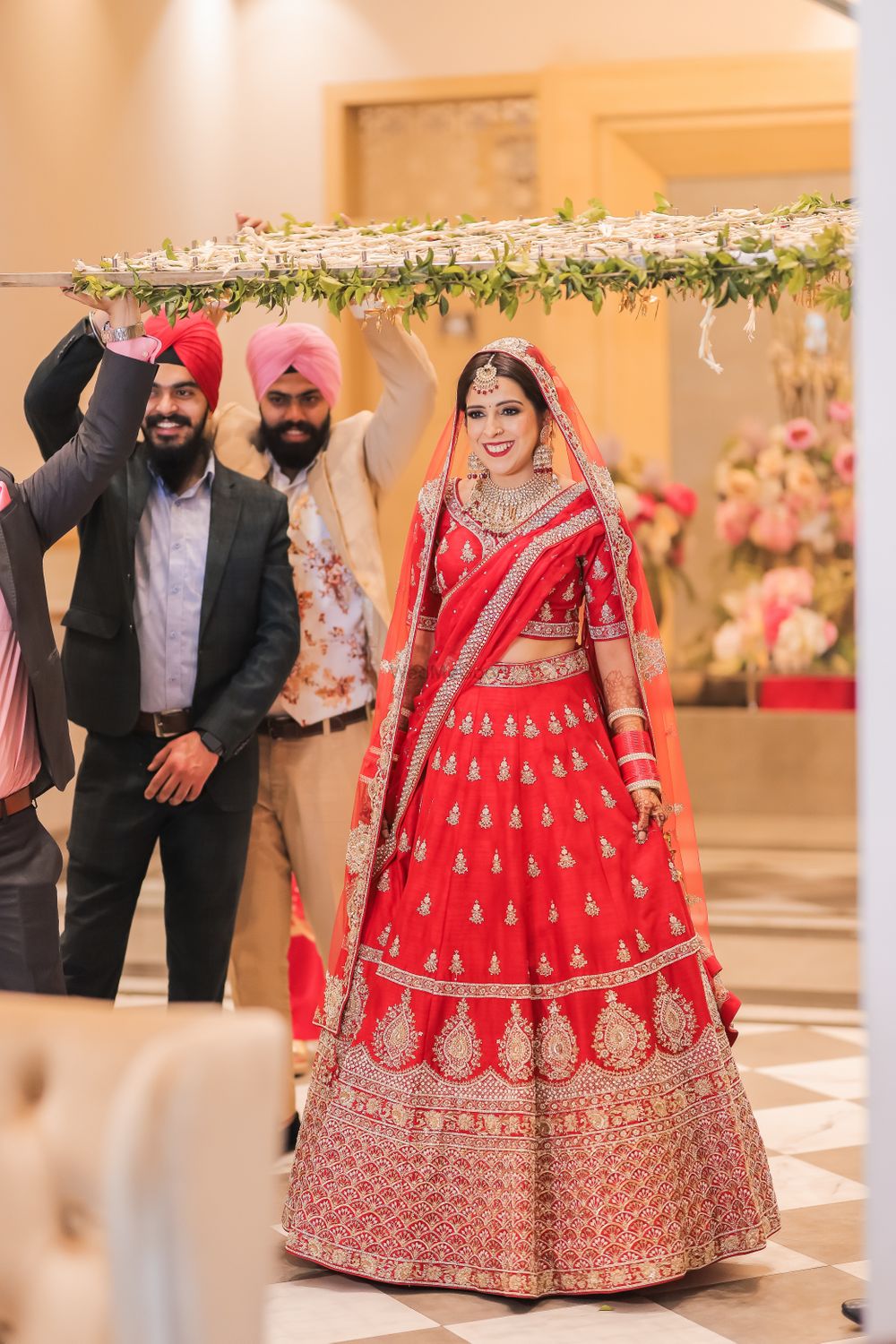 Photo of bride making her entry in a bright red lehenga