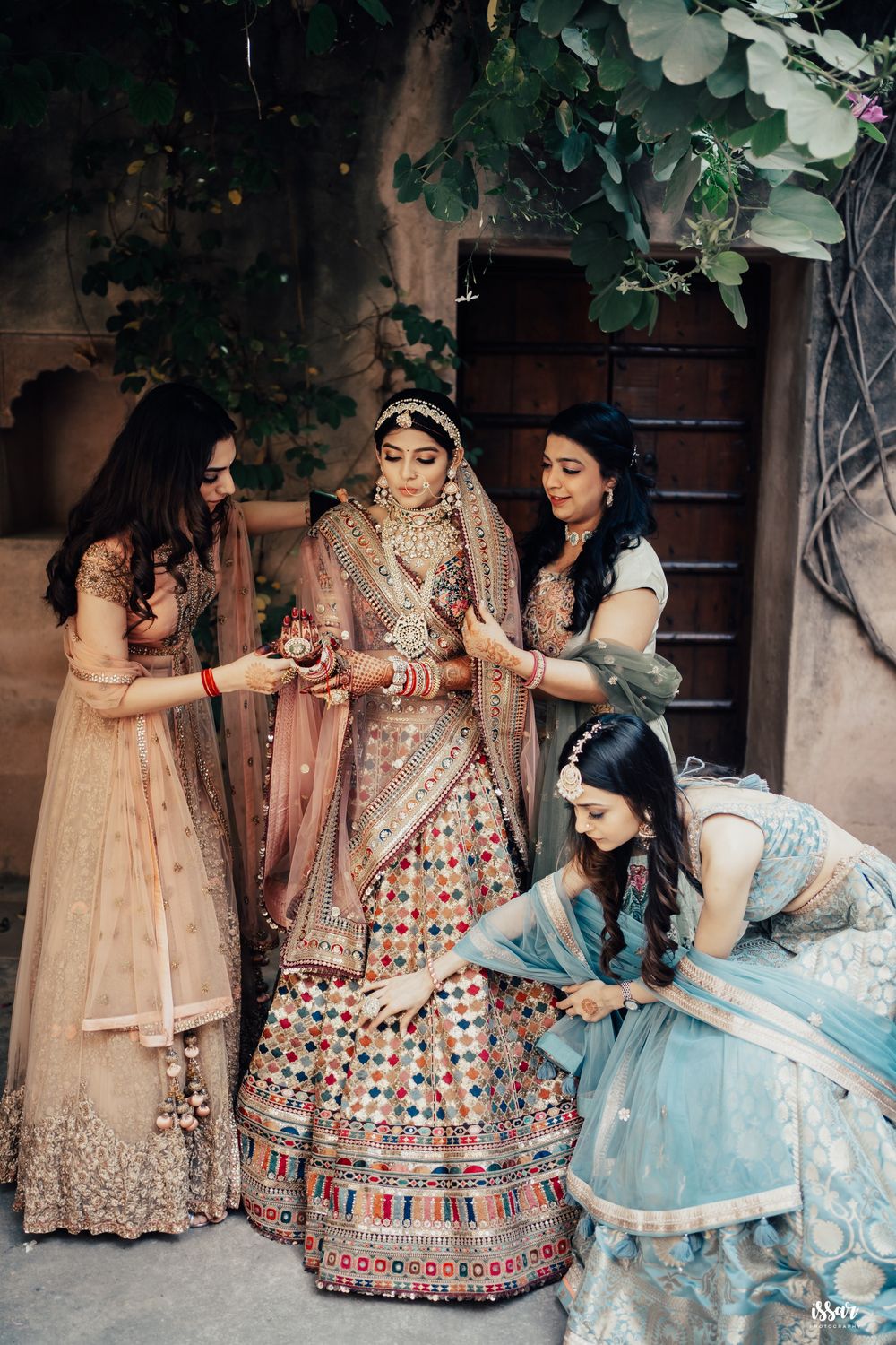 Photo of Bridesmaids helping the bride getting ready for her big day