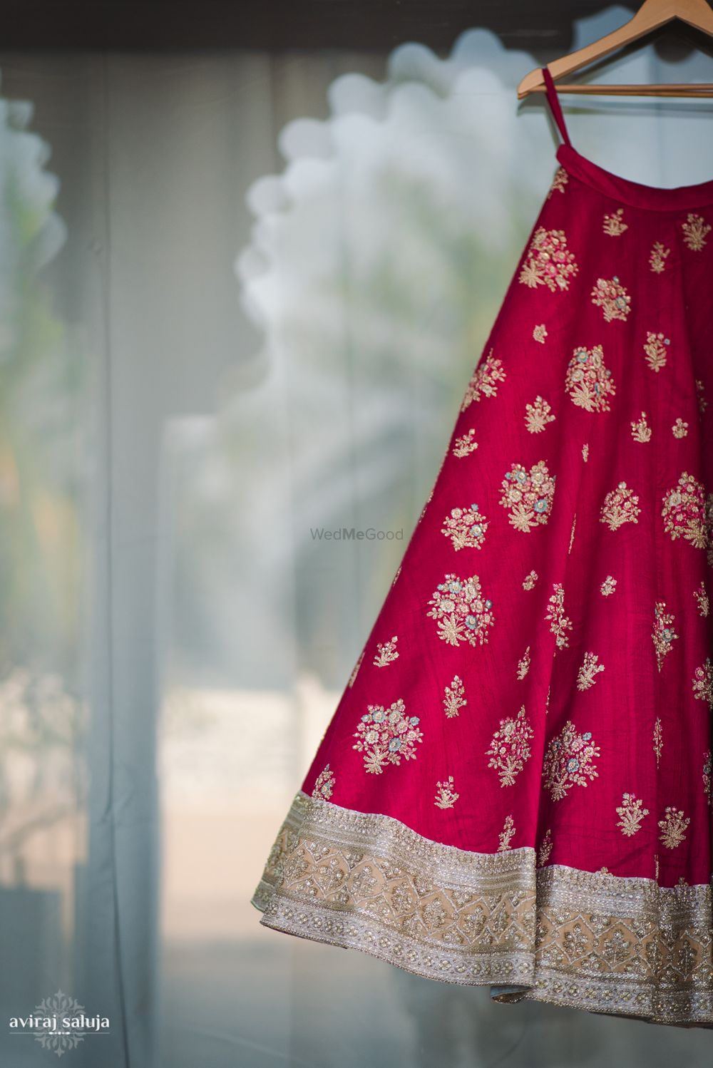 Photo of Red bridal lehenga on hanger with gold motifs
