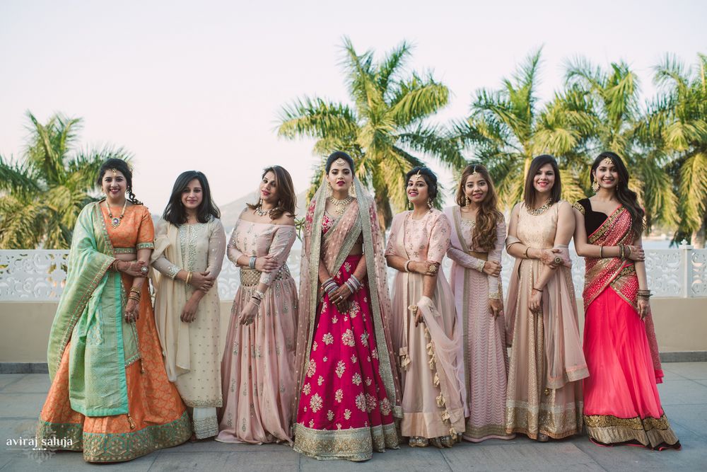 Photo of Bride standing with bridesmaids