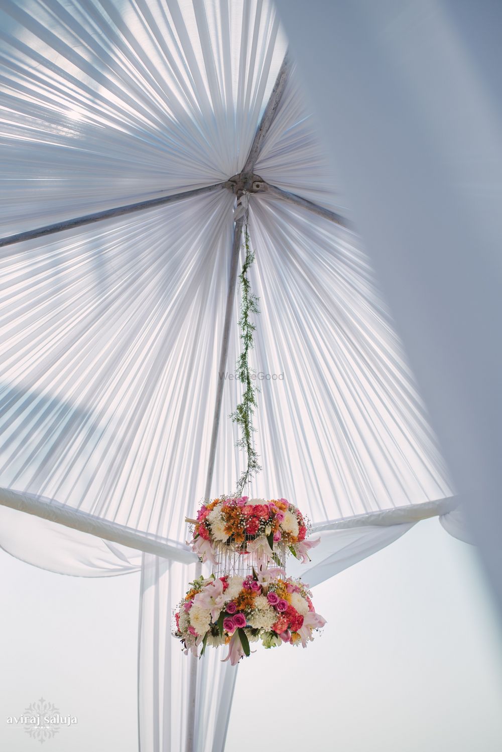 Photo of Floral chandelier hanging from white mandap
