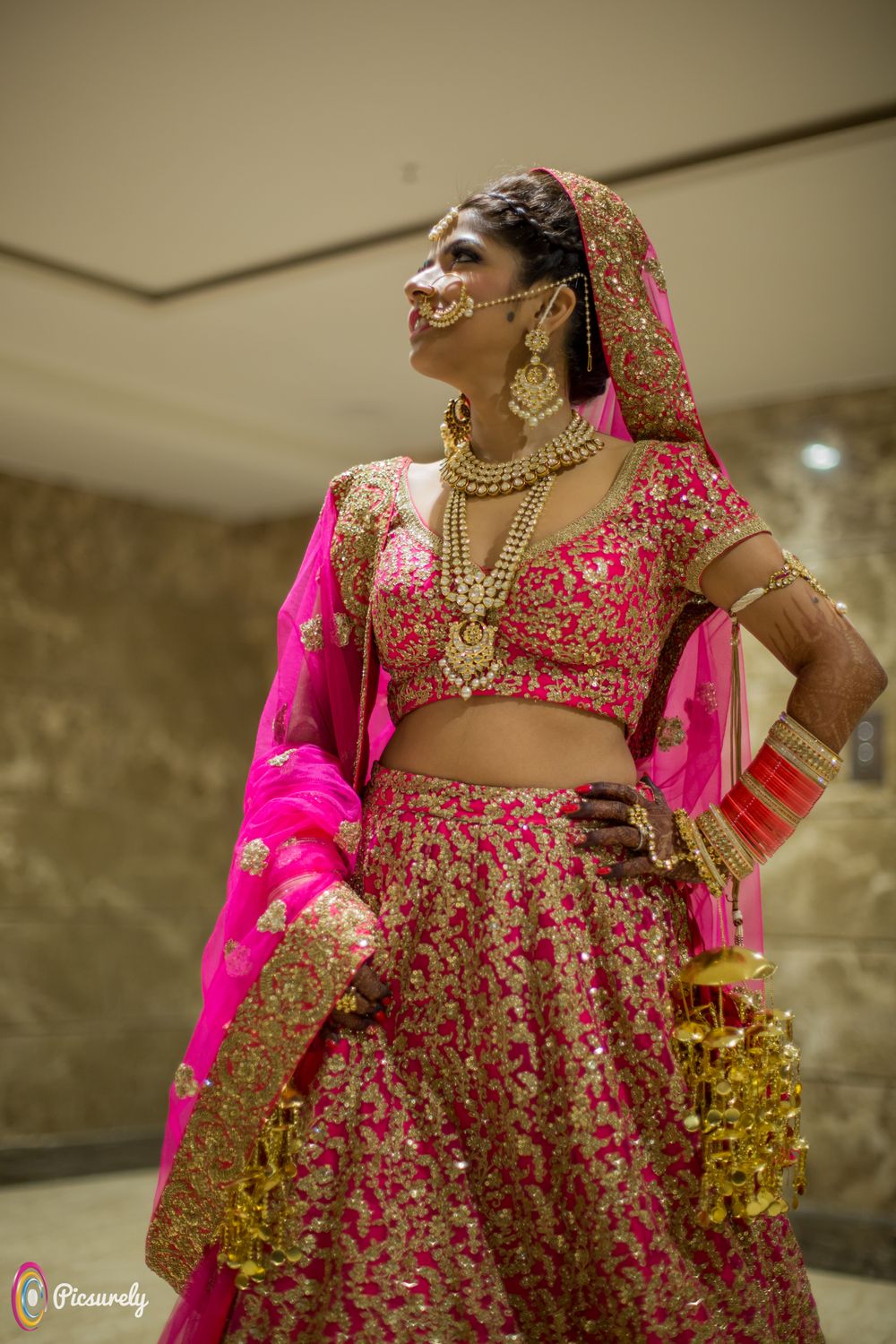 Photo of Bride in hot pink and gold Sabyasachi lehenga