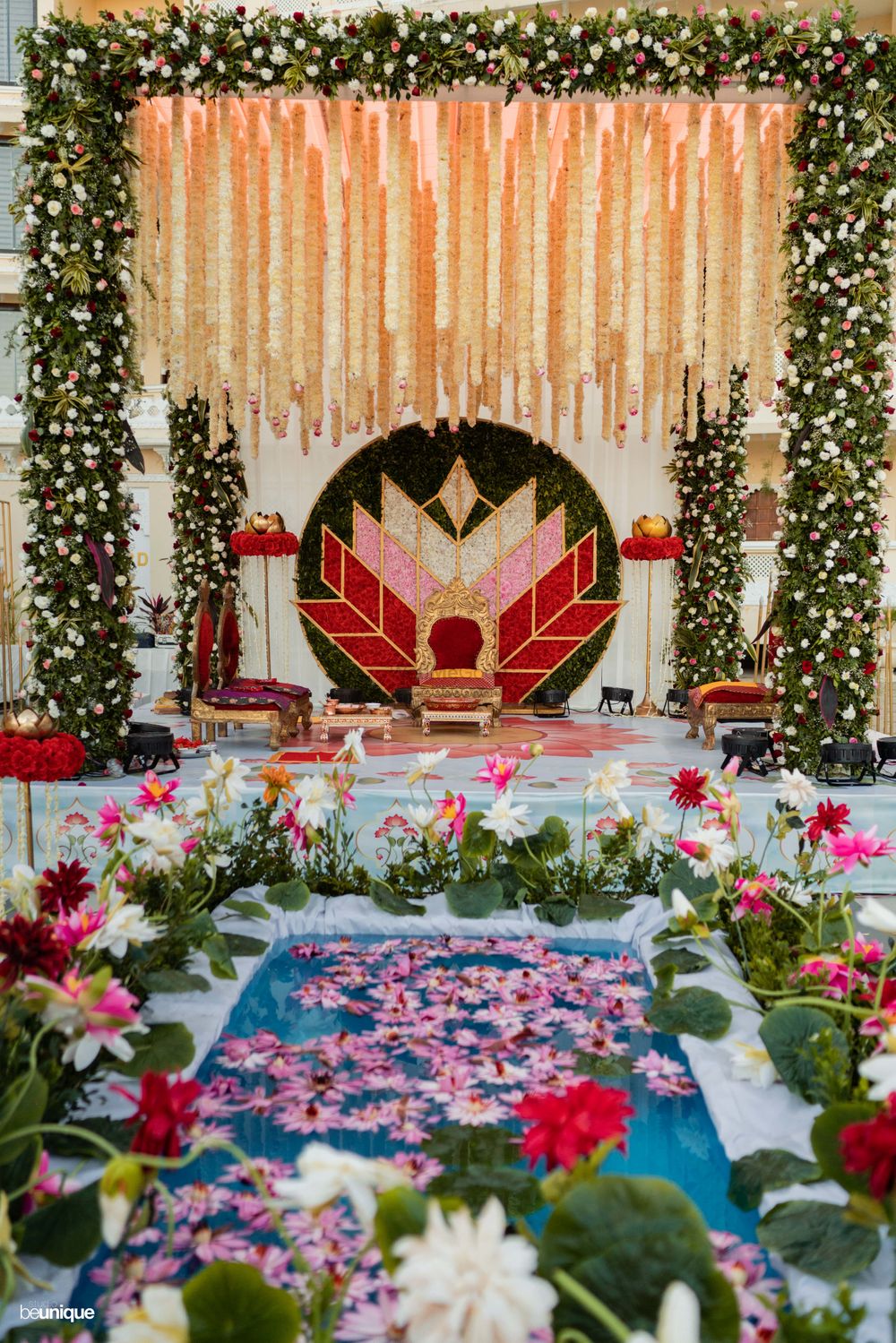 Photo of Floral mandap infront of a mini pool filled with flowers.