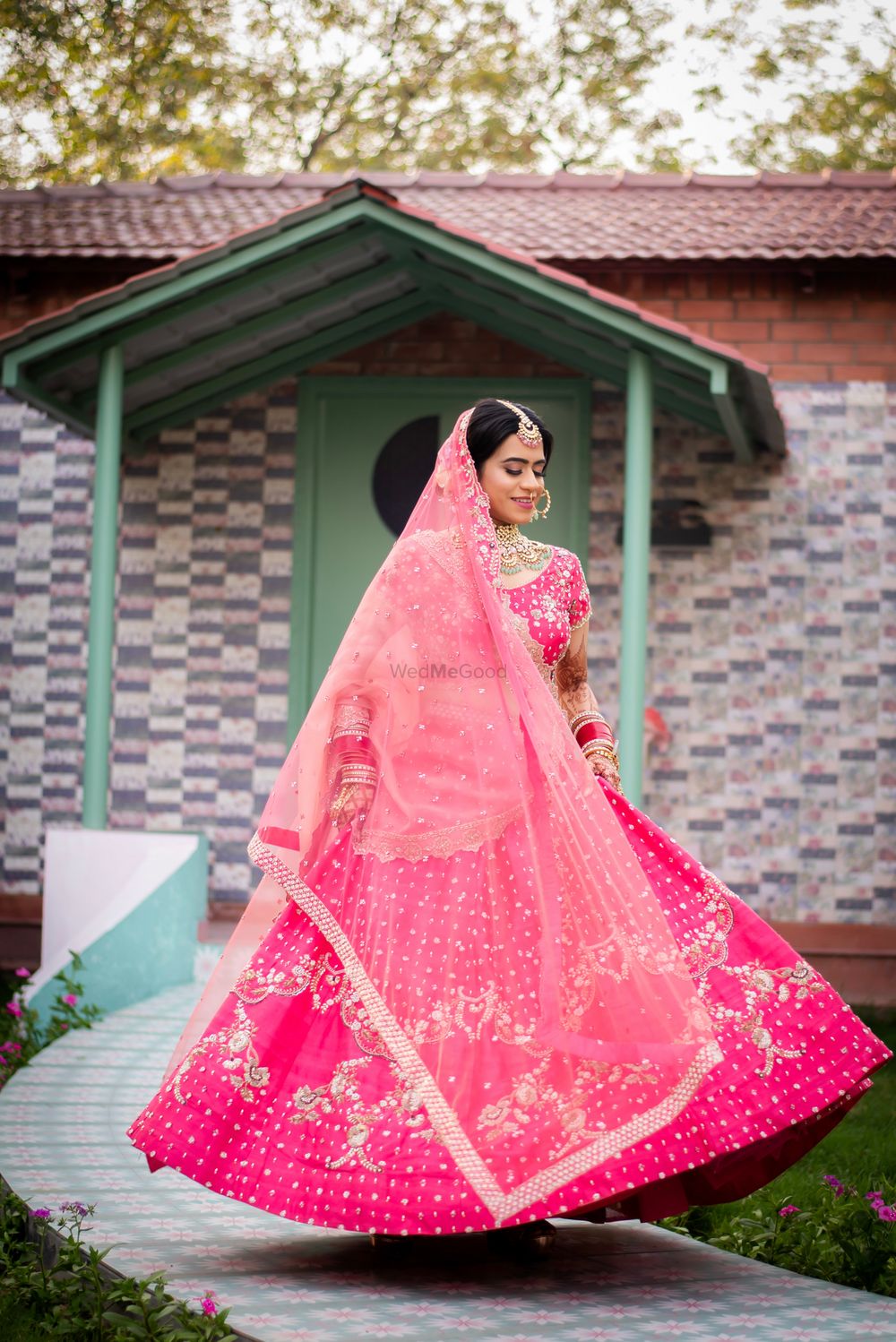 Photo of Twirling bride in a Pink lehenga