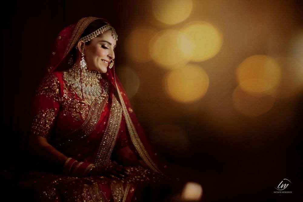 Photo of Candid shot of a bride dressed in a red lehenga.