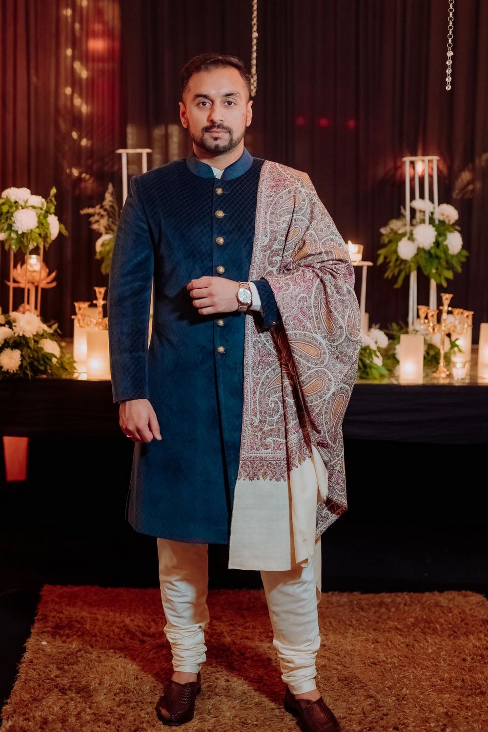 Photo of Groom wearing a velvet bandhgala with paisley motif shawl.