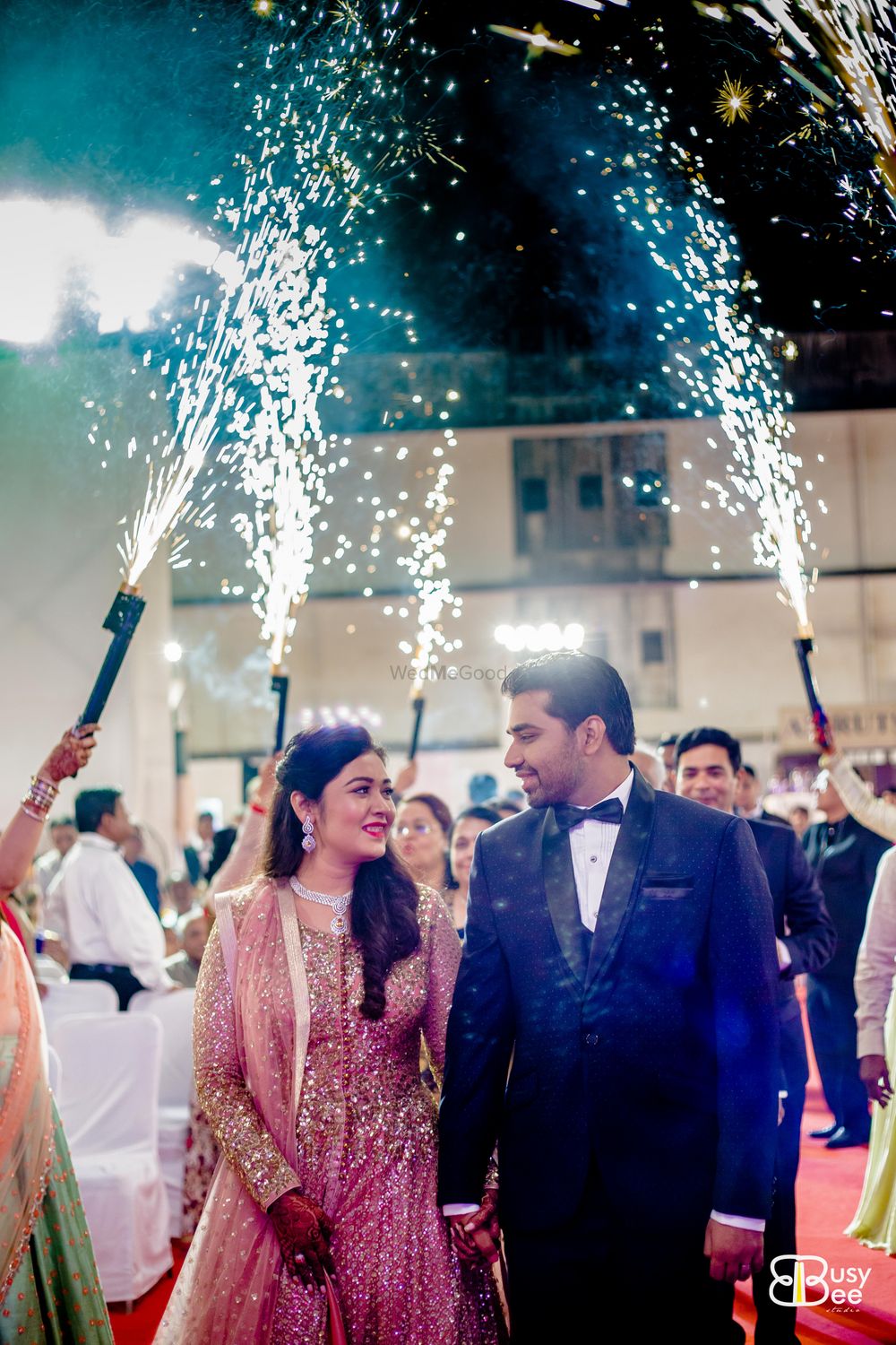 Photo of Guests holding cold pyros on bride and groom entry