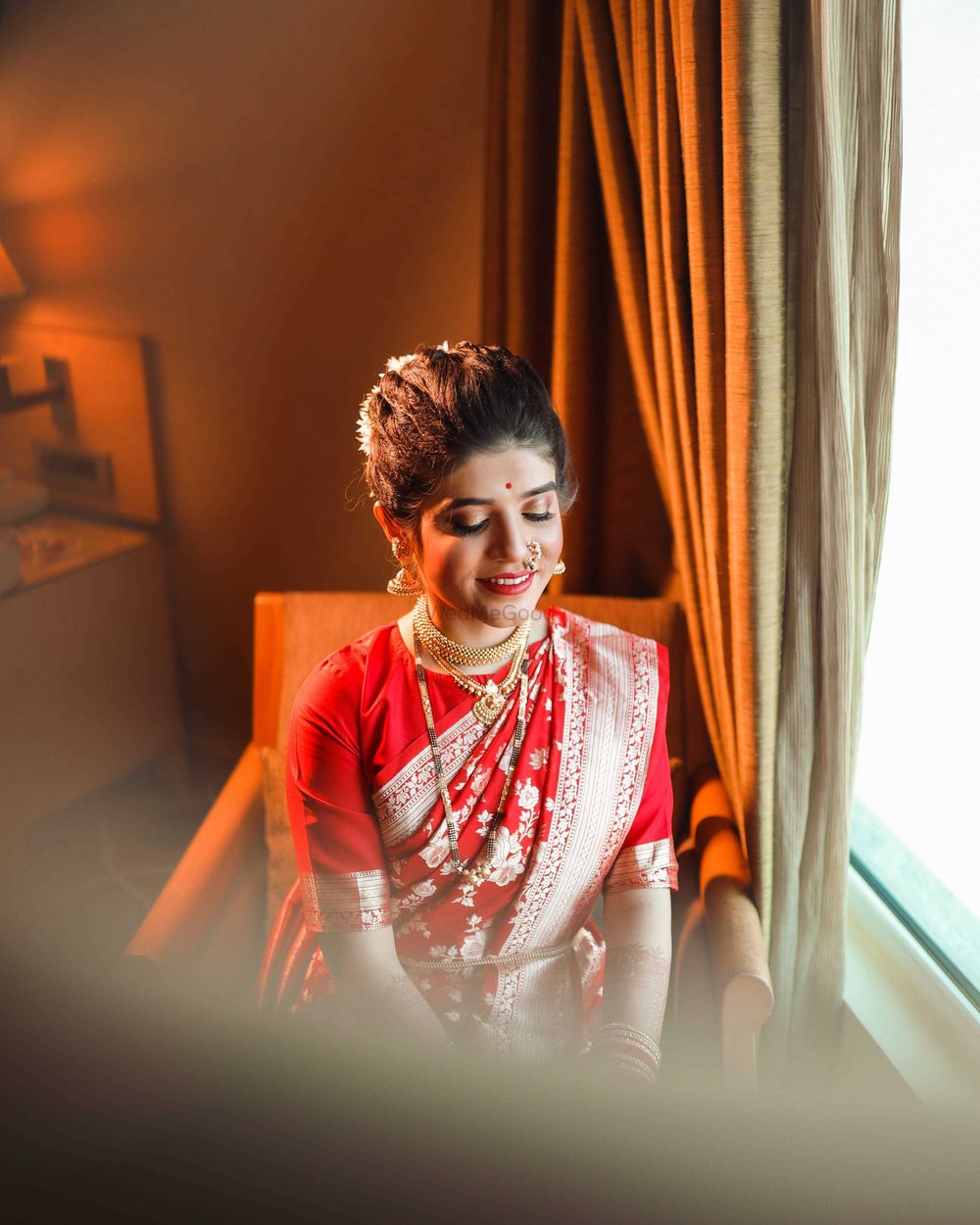 Photo of A marathi bride dressed in a red and gold saree.