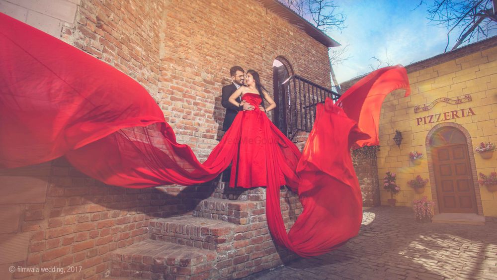Photo of Glam bollywood pre wedding shoot with flowing red gown