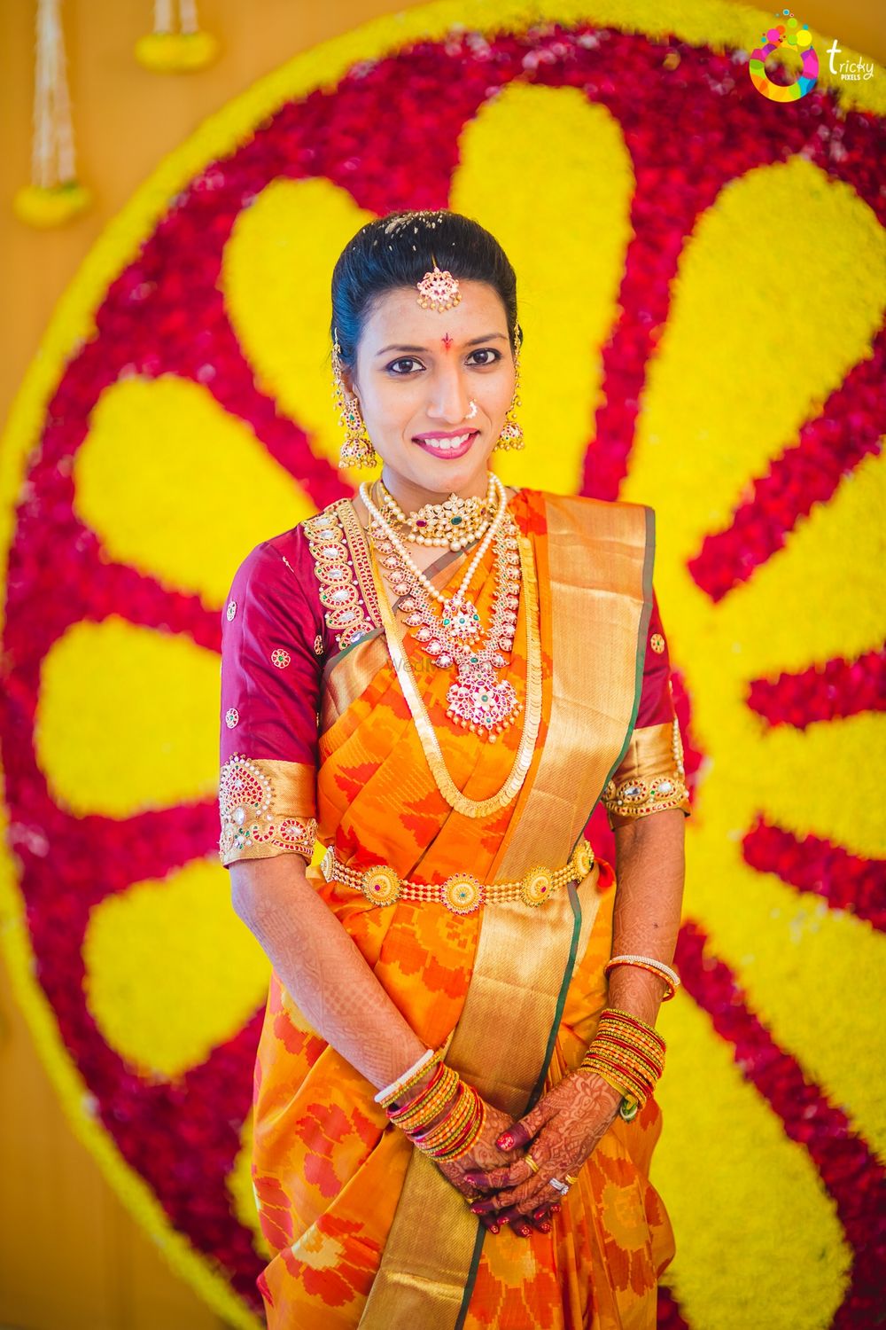 Photo of South Indian bride wearing orange and gold kanjivaram saree