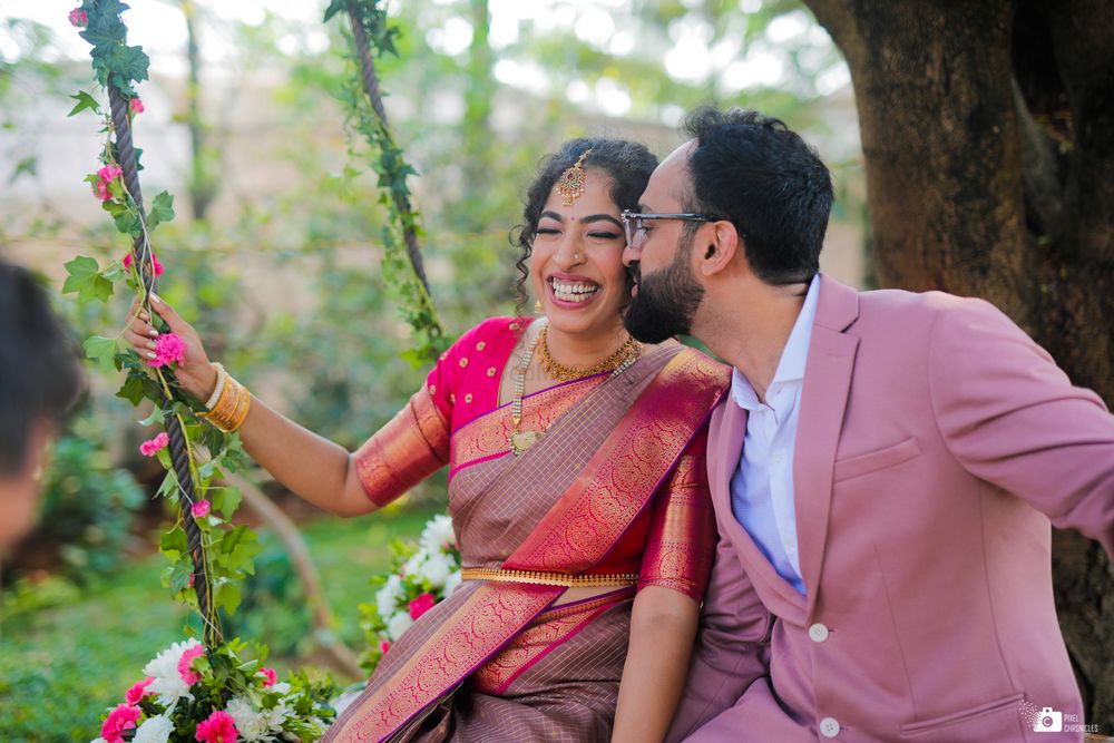 Photo of A South Indian couple posing on a swing.