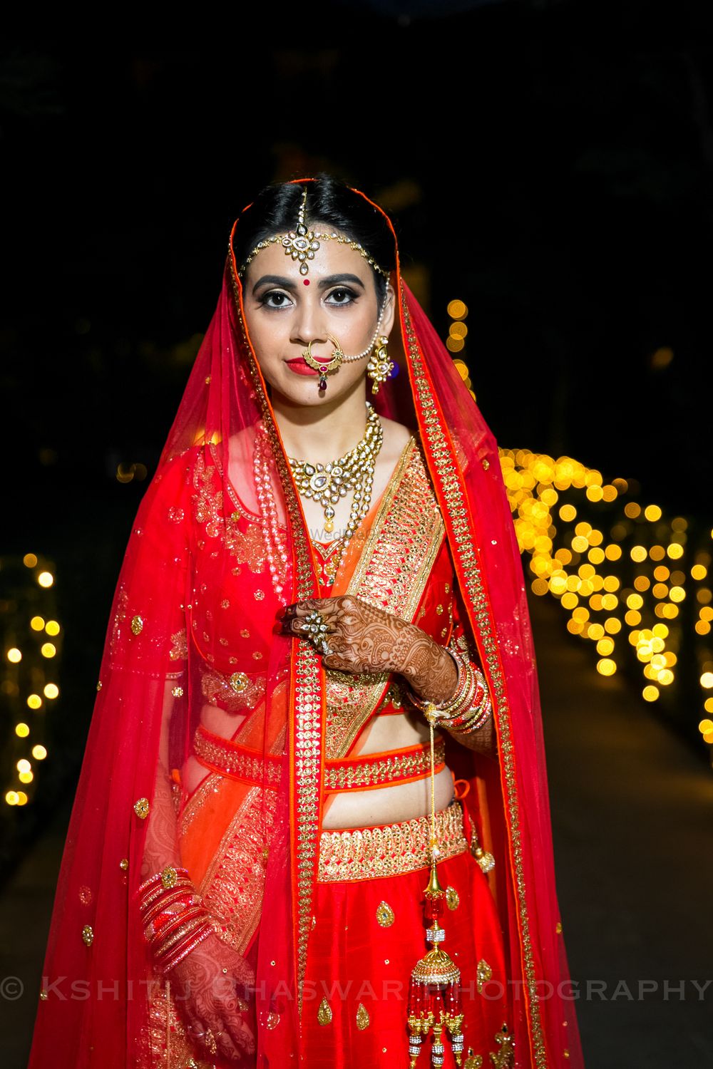 Photo of Bride in bright lehenga with waist belt and kaleera