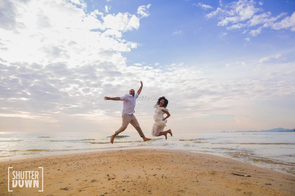Photo of Beach pre wedding shoot with couple jumping shot