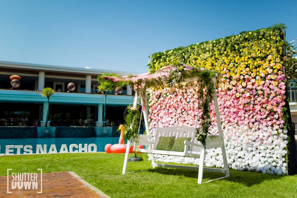 Photo of Mehendi Photo Booth idea with floral wall and swing