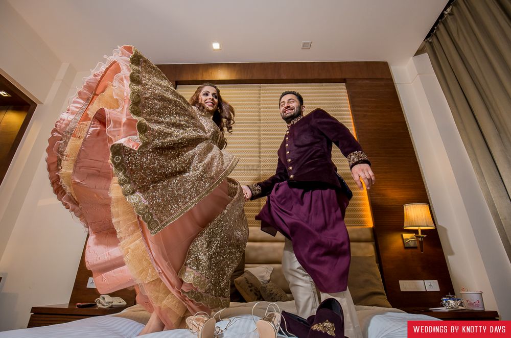 Photo of Fun couple shot with them jumping on bed