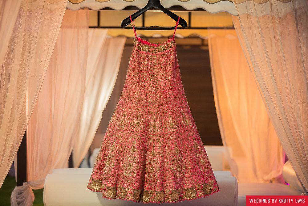 Photo of Coral lehenga with gold sequin work on hanger