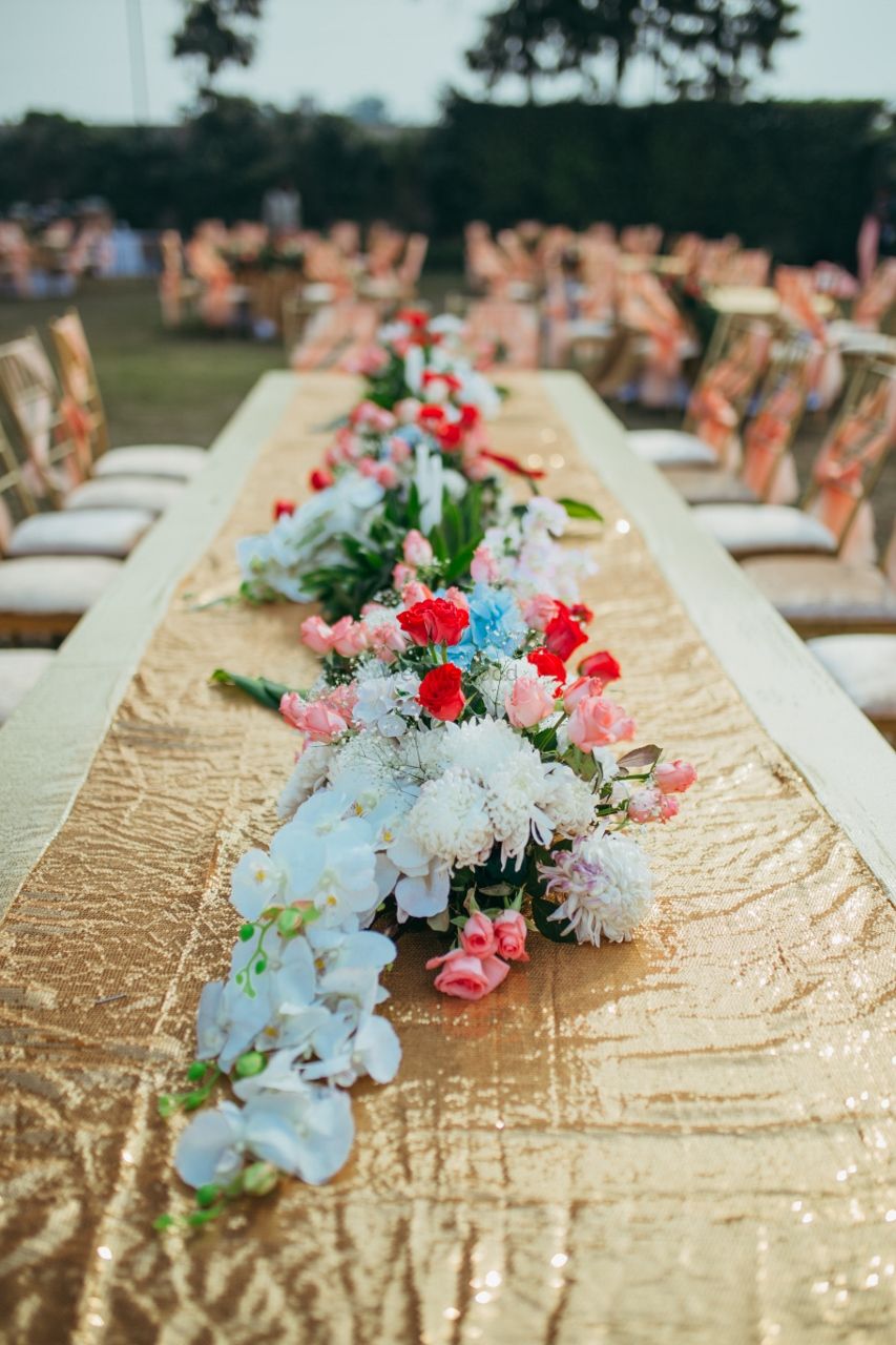 Photo of Gold table runner with sequins and floral arrangement