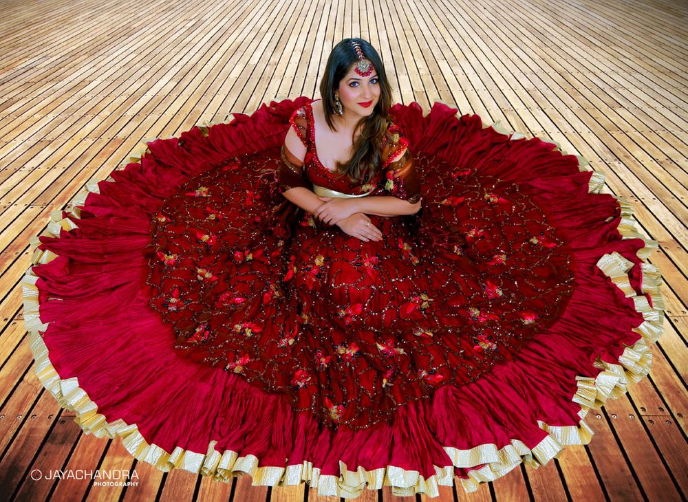 Photo of Bride with maroon flared lehenga on the floor