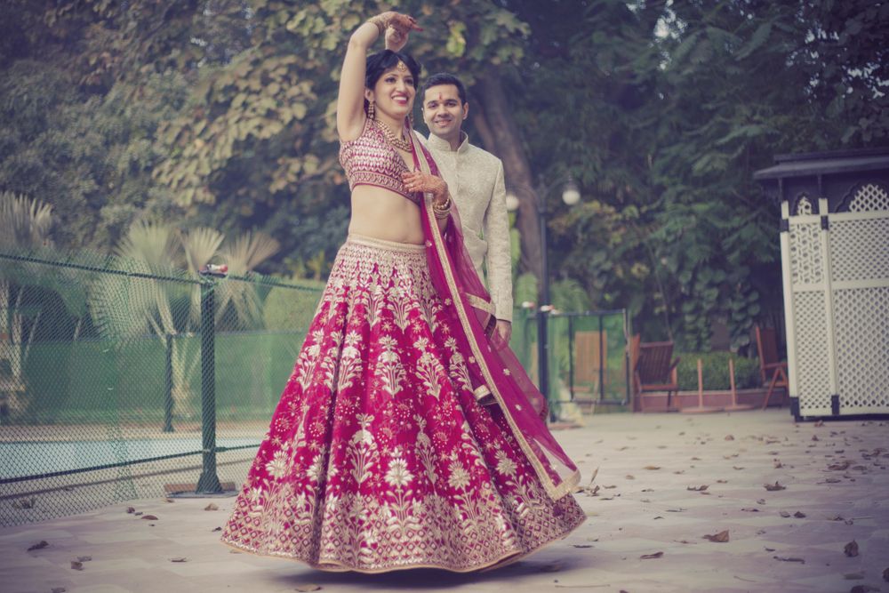 Photo of Bride twirling in red bridal lehenga with white embroidery