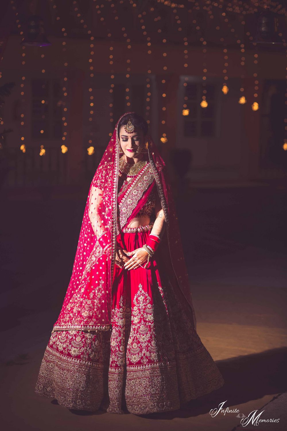 Photo of Bride posing in deep red bridal lehenga with threadwork