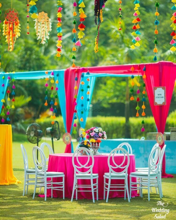 Photo of Colourful mehendi decor with white chairs