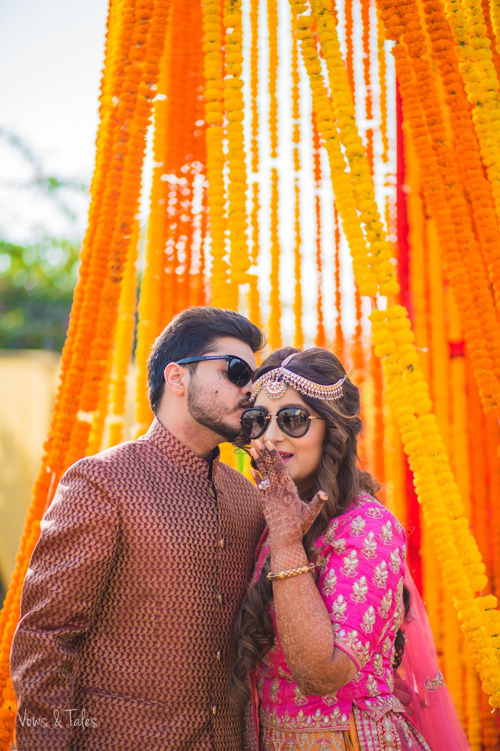 Photo of Mehendi couple portrait with groom kissing the bride