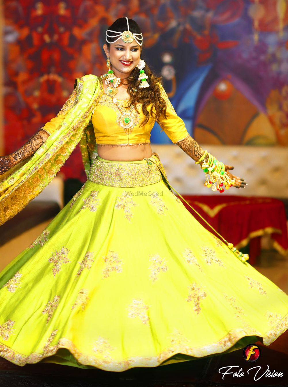 Photo of Bride twirling in light green and yellow mehendi lehenga