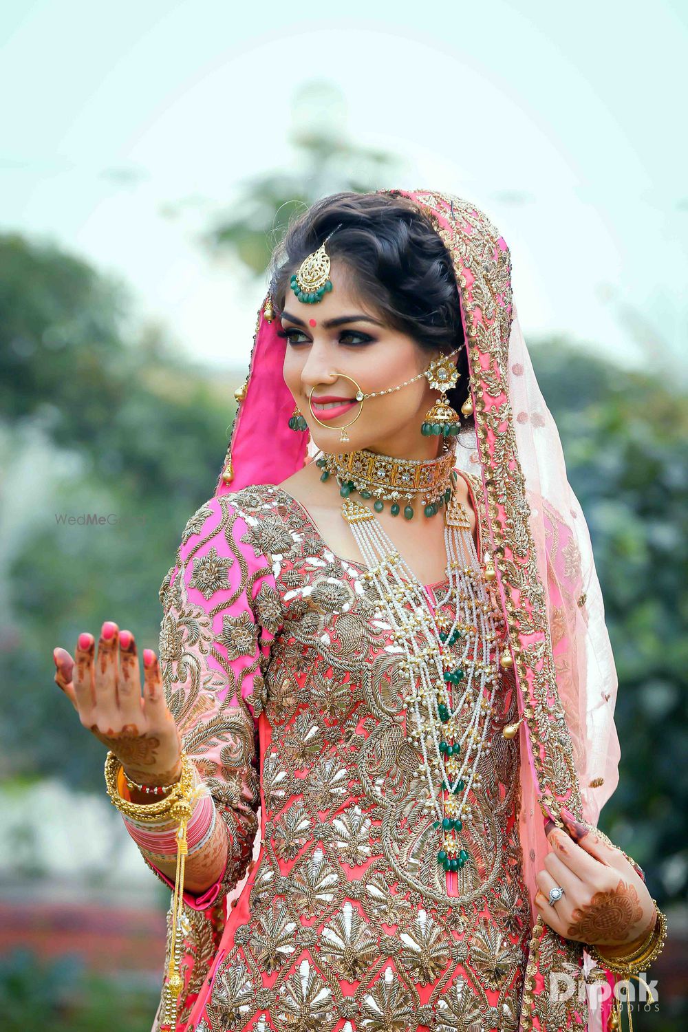 Photo of Bride wearing layered jewellery with green beads with choker and satlada