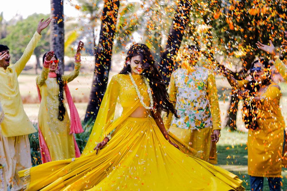 Photo of Bride twirling on haldi in yellow outfit