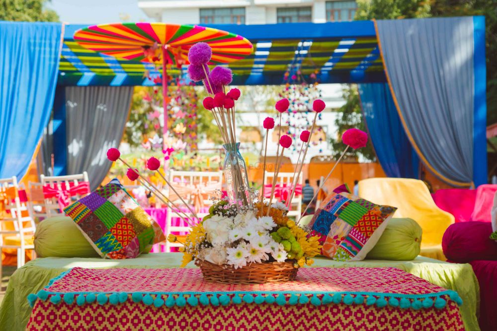 Photo of Floral basket with pom pom sticks in table setting