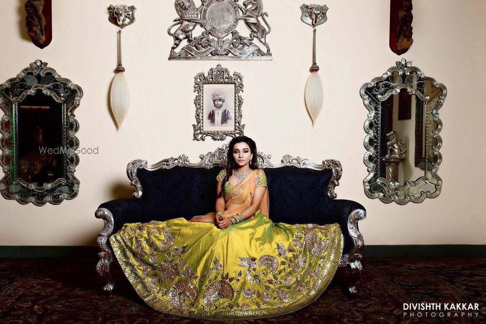 Photo of Bride sitting with flared out lehenga on sofa