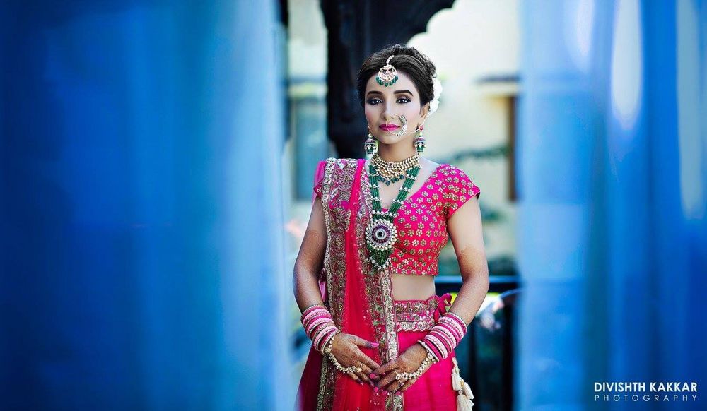 Photo of Red bridal lehenga with contrasting green jewellery