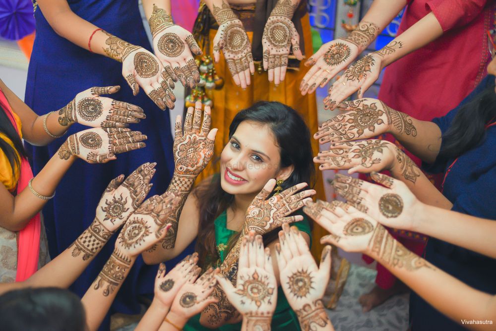 Photo of Bride and bridesmaids showing off mehendi