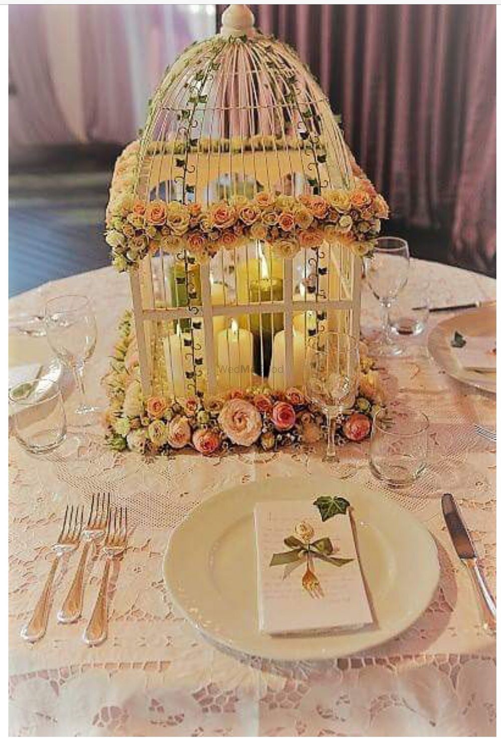 Photo of Gorgeous floral birdcage with lit candle as table centerpiece