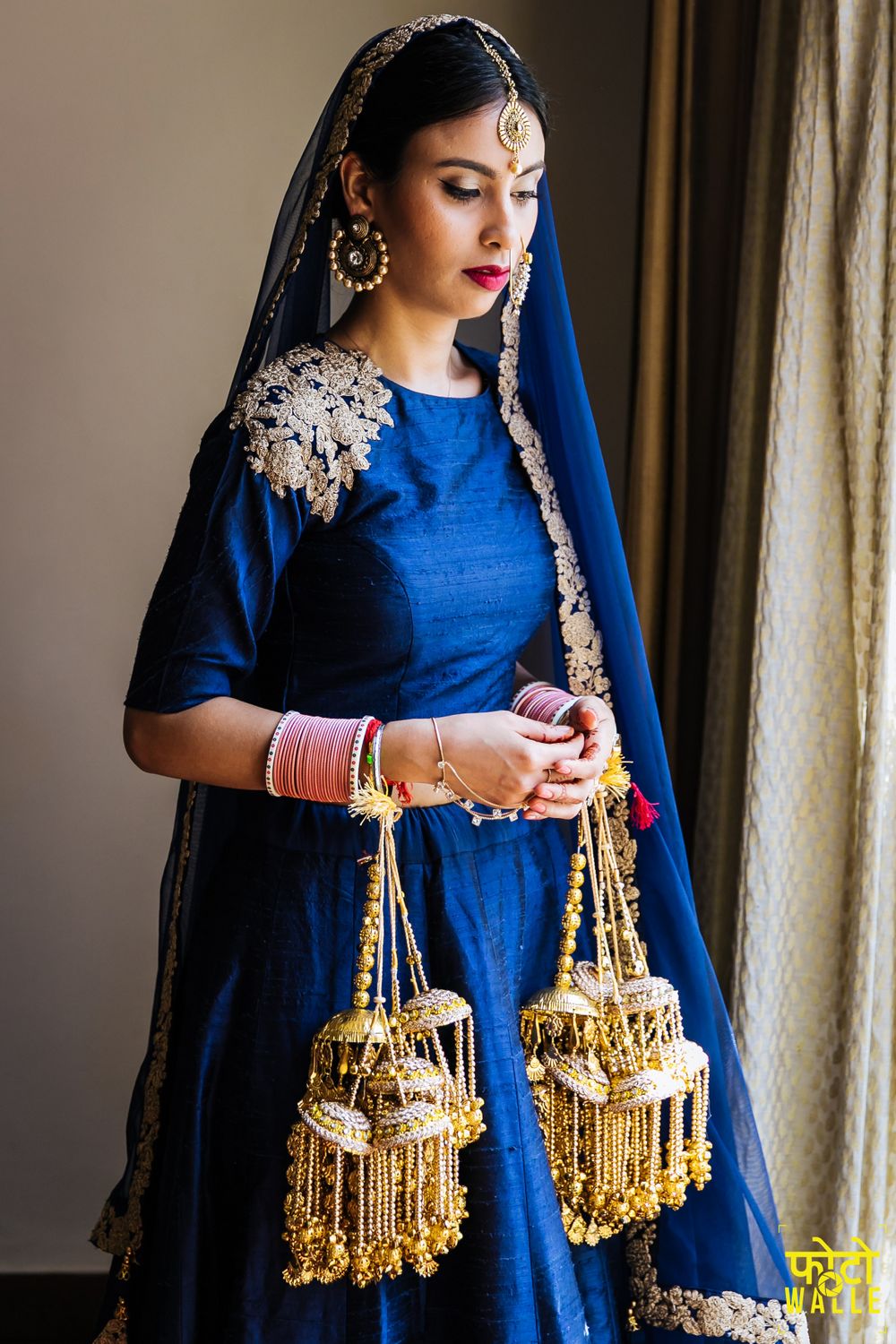 Photo of Minimal bride wearing blue lehenga and kaleeras