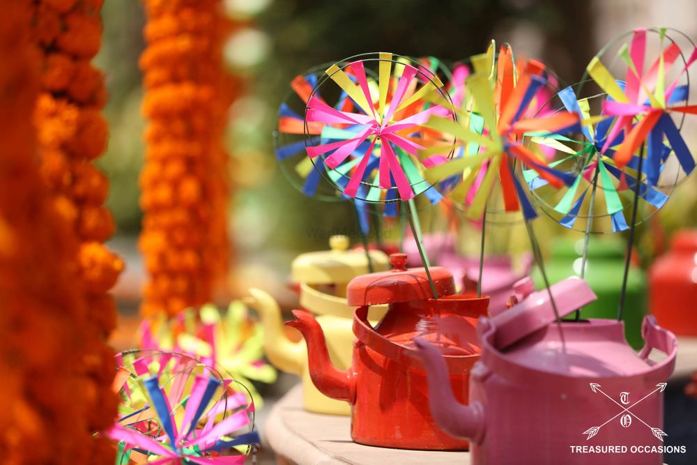 Photo of Colorful paper wheels and tea kettle in mehendi decor