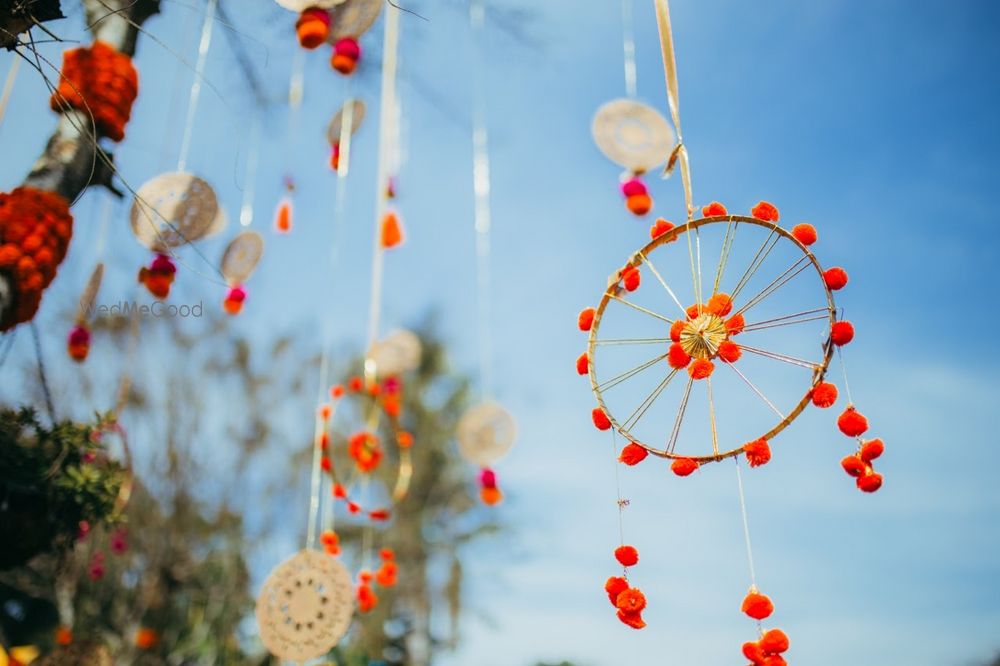 Photo of hanging wheels with pom pom in mehendi decor