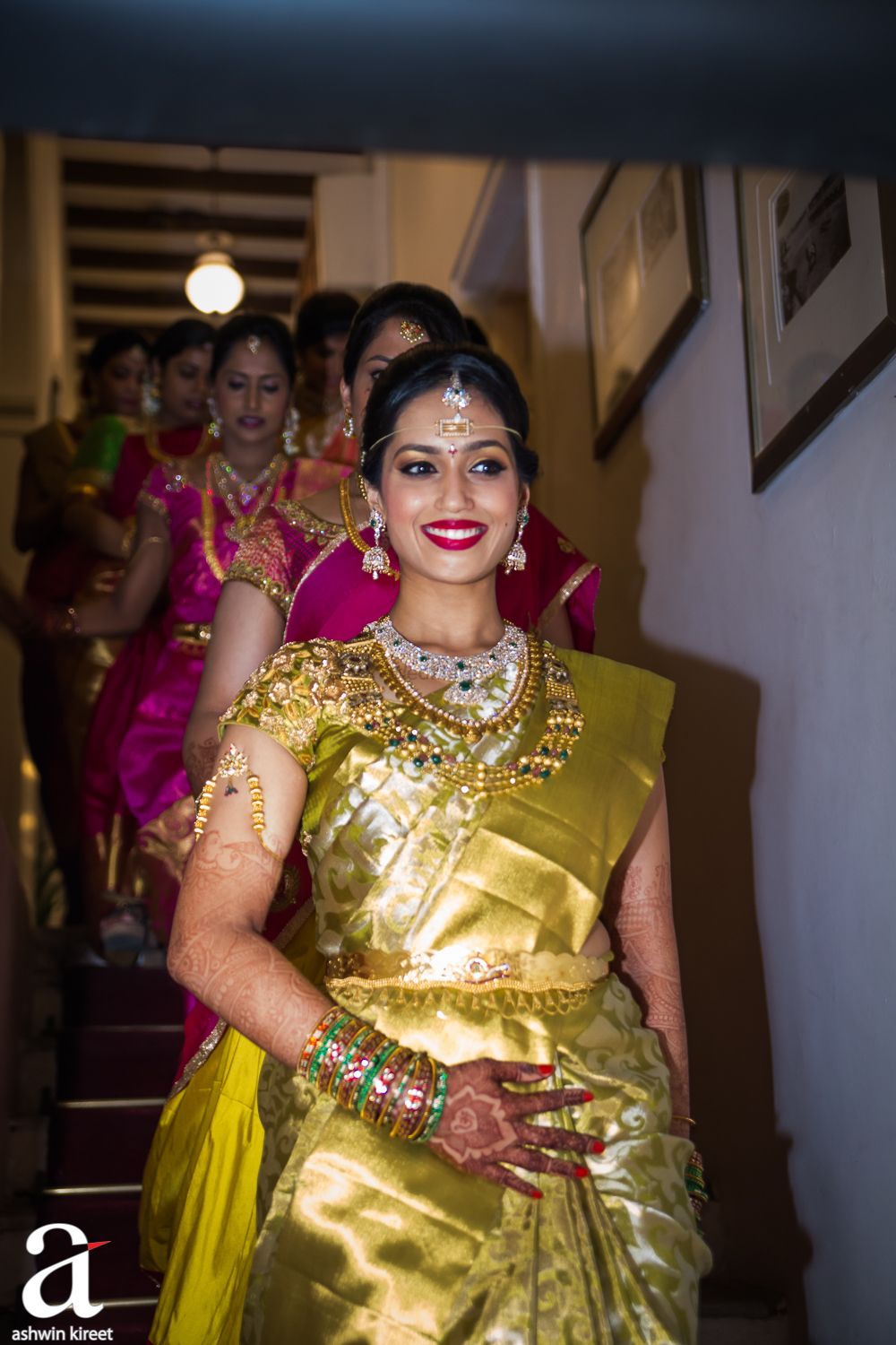 Photo of South Indian bride stepping down the stairs with bridesmaids