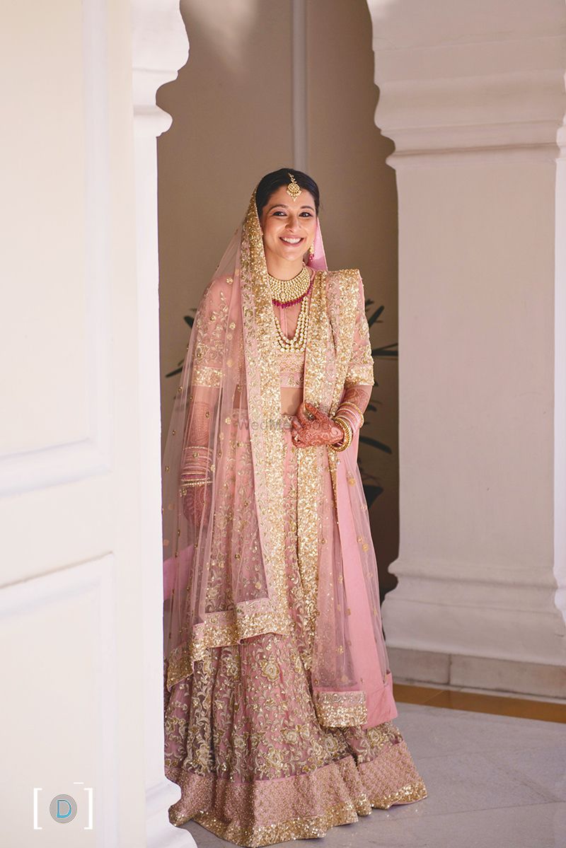 Photo of Shimmery pink pastel pink lehenga with gold sequins
