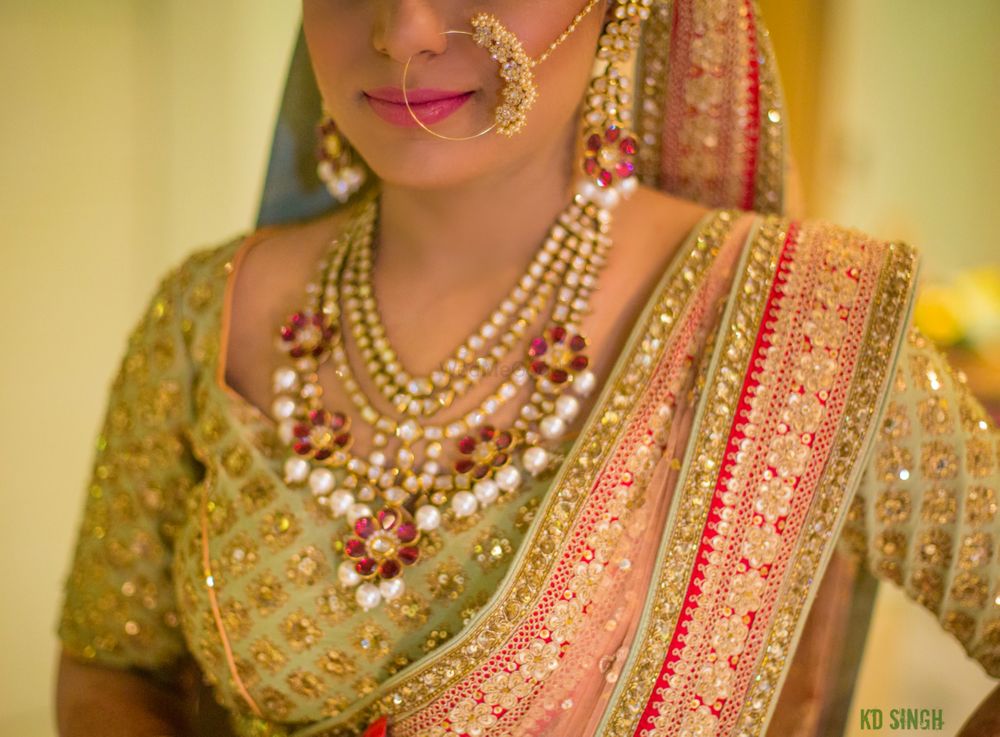 Photo of Bride in green lehenga with red stone and pearl jewellery