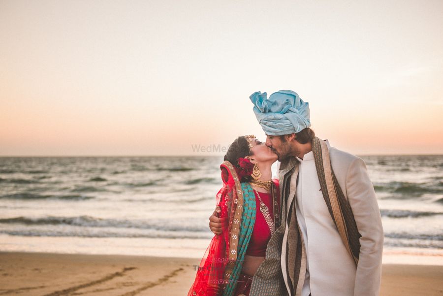 Photo of Romantic couple shot kissing on the beach