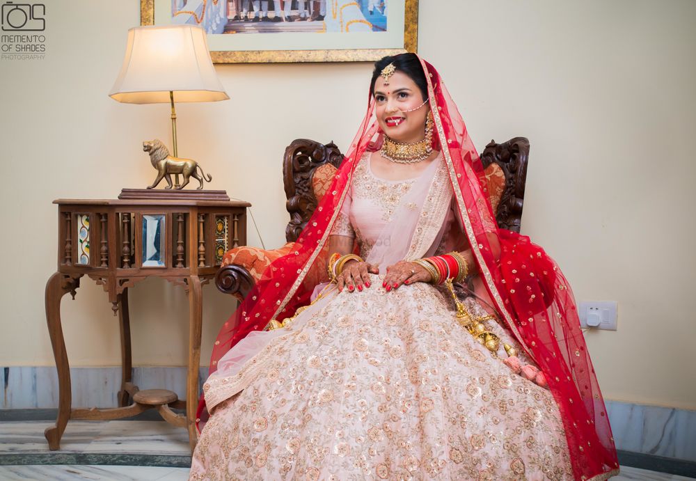 Photo of Monotone bridal pink lehenga with red dupatta over the head
