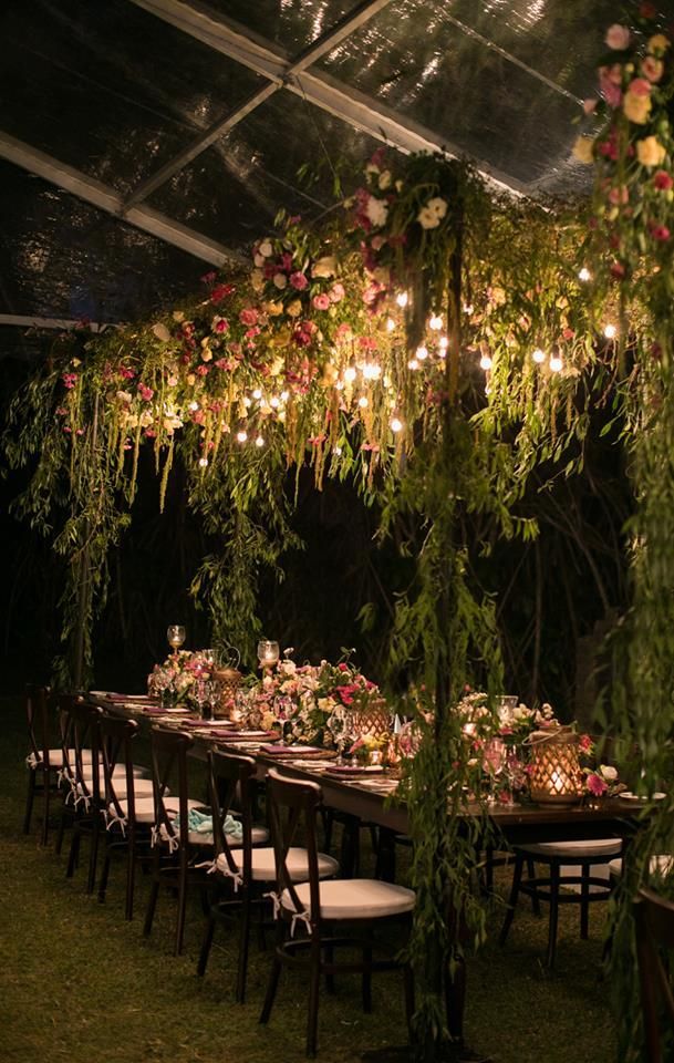 Photo of Beautiful outdoor sit down dinner set up with floral and lighting