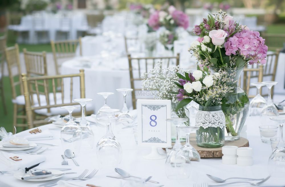 Photo of Gorgeous table setting with white and lavender flowers in glass jars