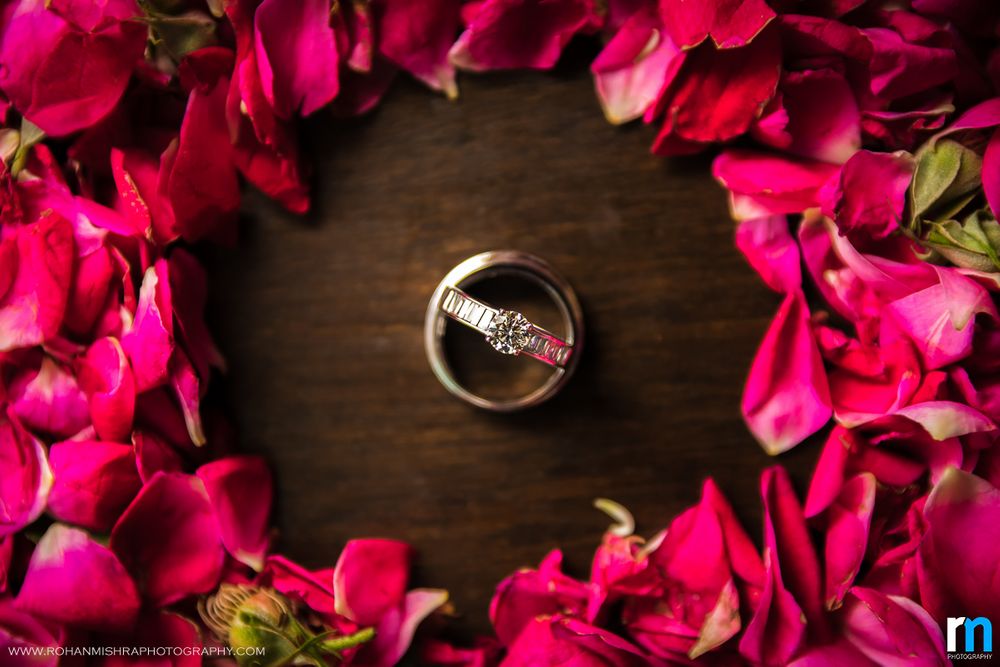 Photo of Couple Engagement Ring Surrounded By Rose Petals