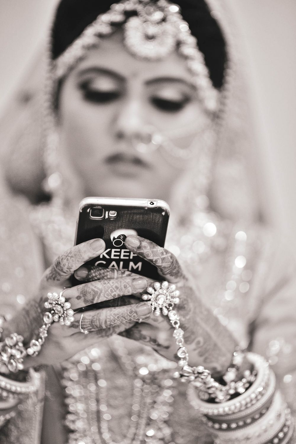 Photo of black and white bridal shot with bride on her phone