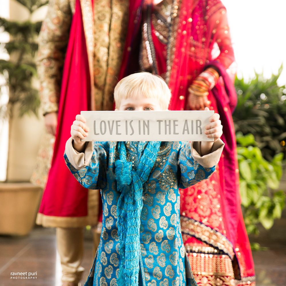 Photo of Couple with kid at wedding holding placard