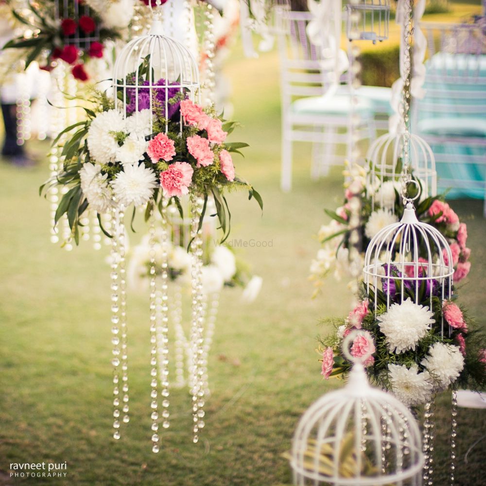 Photo of White birdcage with florals and hanging pearl strings