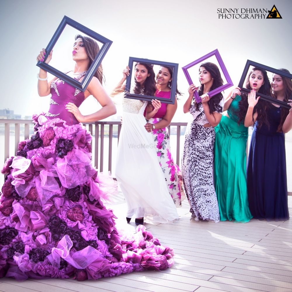 Photo of Bride and bridesmaids posing with frames
